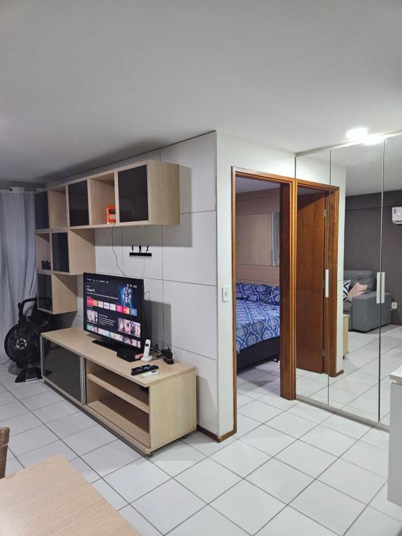 uma sala de estar com televisão e um quarto em Ap em Maceió todo equipado á 150m da praia de Ponta Verde em Maceió