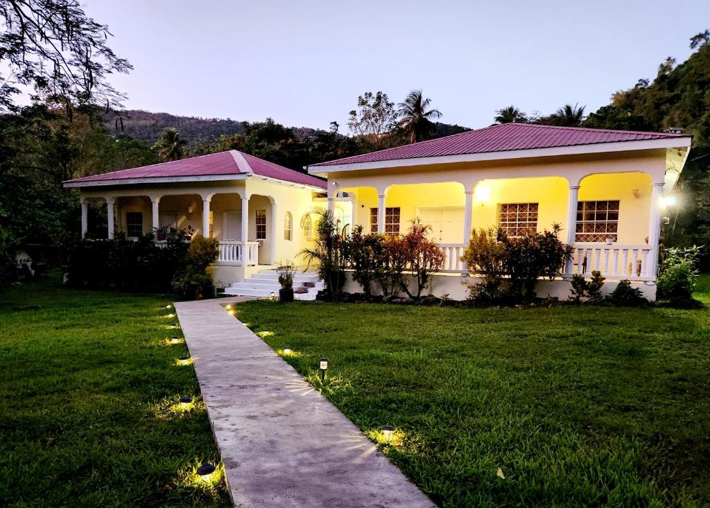 una casa blanca con césped delante en Maison 79, en Soufrière