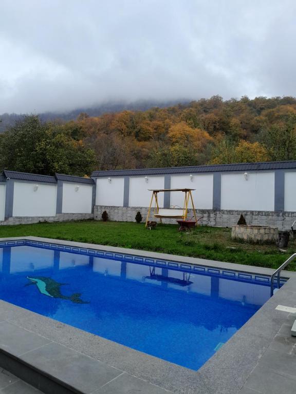 ein Pool mit einer Wippe und einem Spielplatz in der Unterkunft Qafqaz Mountside Chalet in Qəbələ