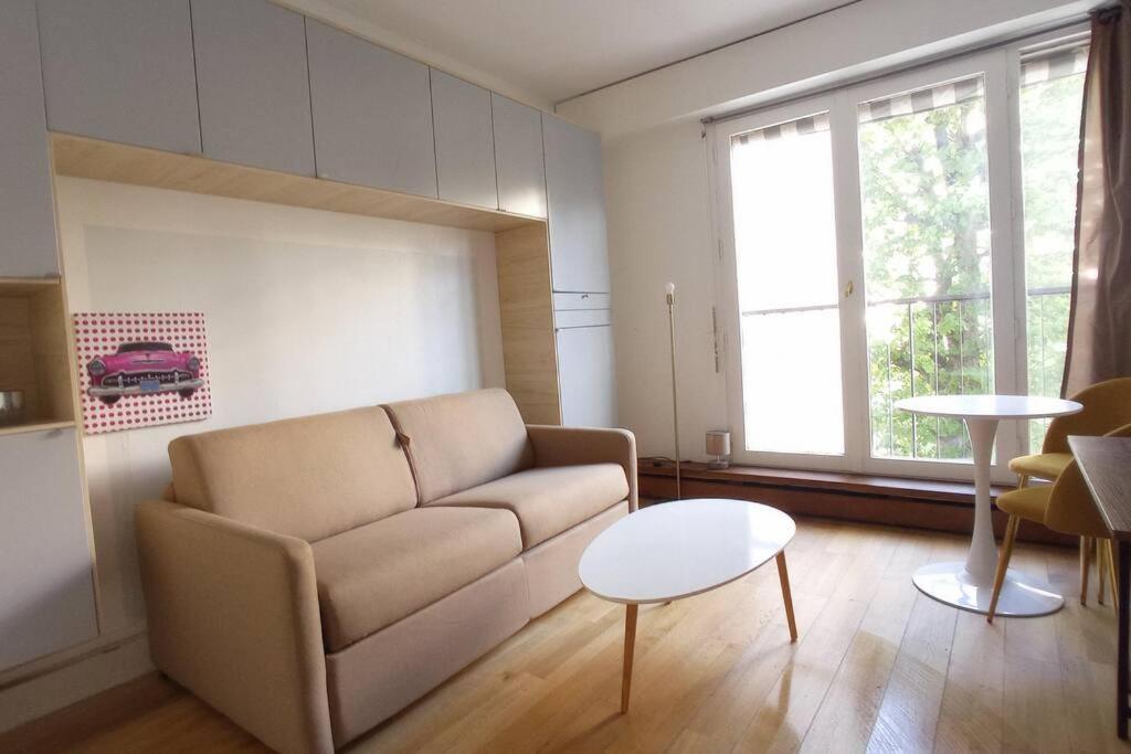 a living room with a couch and a table at Jardin du Ranelagh in Paris