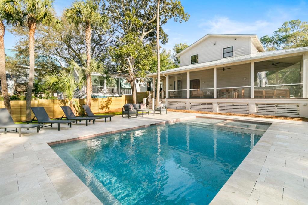 a swimming pool in front of a house at 1st Block E Hudson - Green Wave - Newly Remodeled - Pool and Hot Tub - Ideal Central Location in Folly Beach