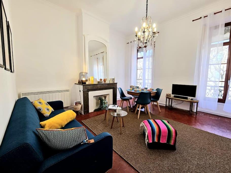 a living room with a blue couch and a table at Le victor hugo - coeur de ville in Nîmes