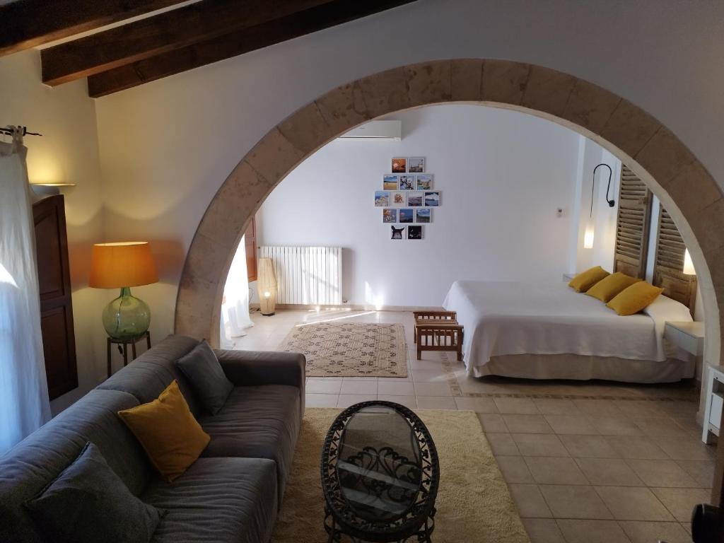 ein Wohnzimmer mit einem Sofa und einem Bett in der Unterkunft PETIT HOTEL ALGAIDA in Algaida