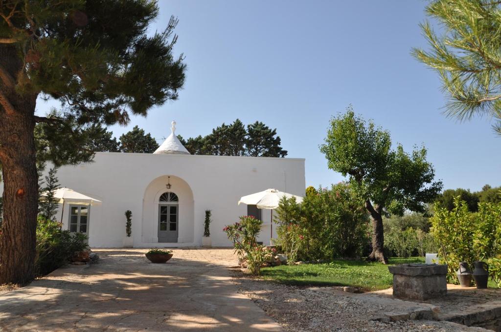 een witte kerk met bomen ervoor bij PalmaFlora villa con trulli in Impalata