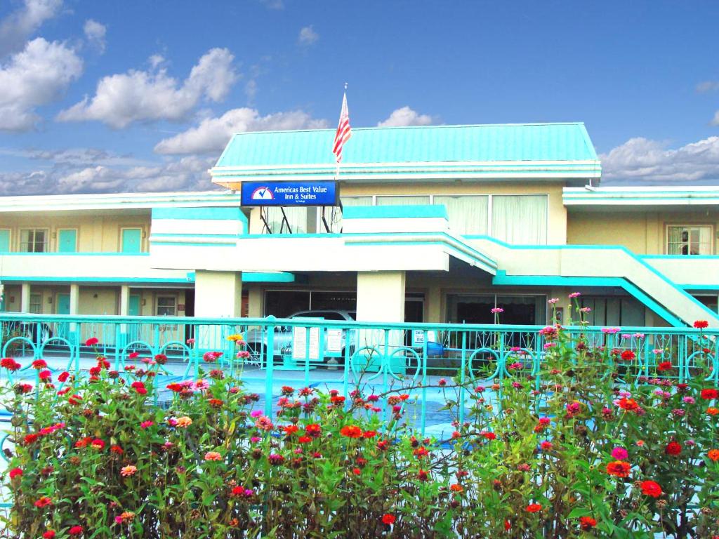 a hotel with red flowers in front of a building at Americas Best Value Inn Suites South Boston in South Boston