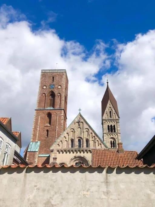 uma igreja com uma torre alta e um relógio em Charmerende bolig nær Domkirken em Ribe