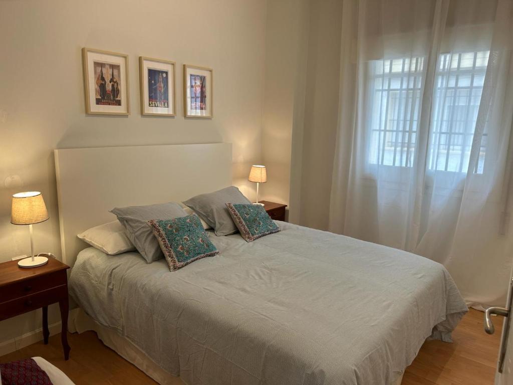 una camera da letto con un letto con due cuscini e una finestra di 2 Bedroom Apartment by Guadalquivir River a Siviglia