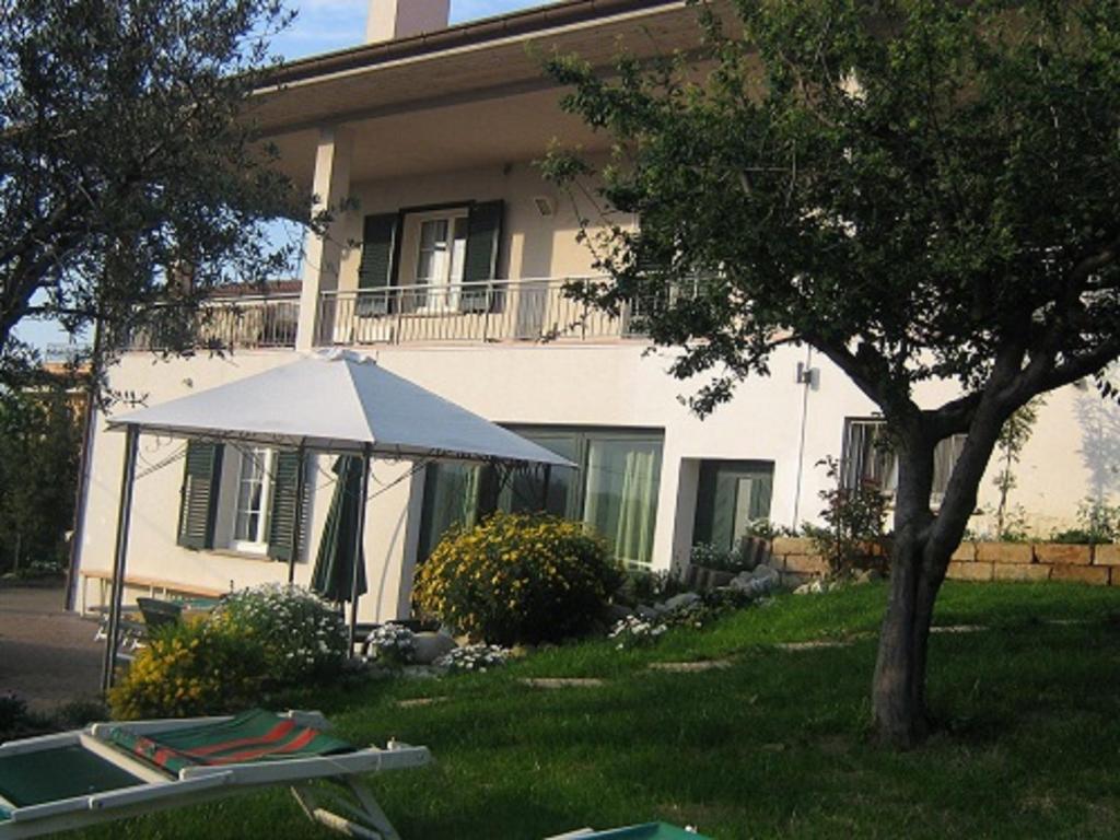 a white umbrella in front of a house at Villa Emma - L'Arte dell'Accoglienza in San Marino