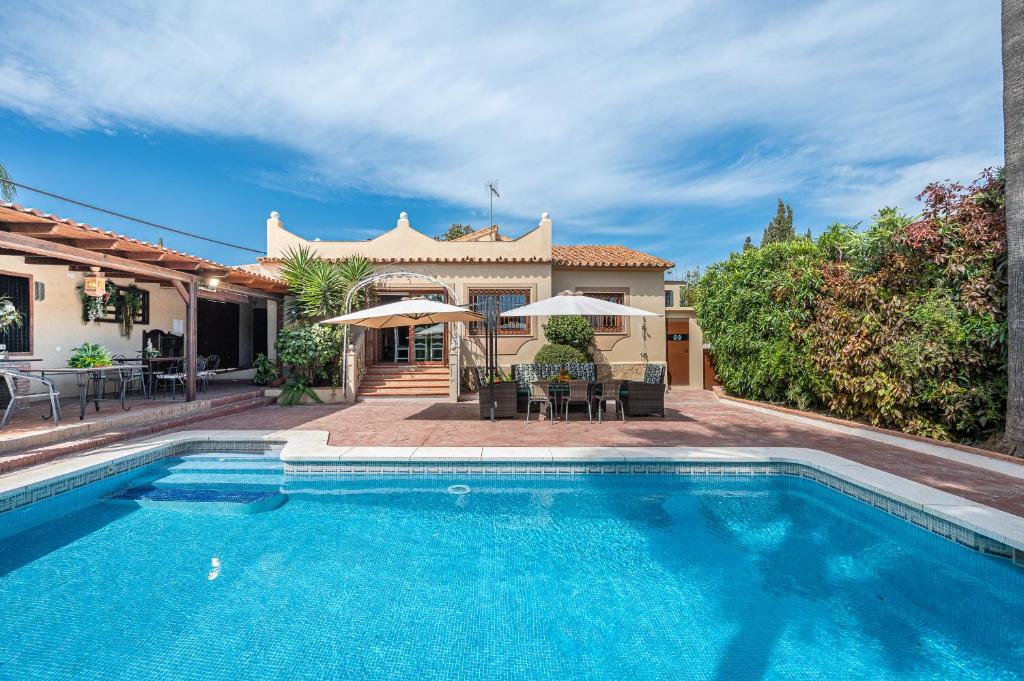 a swimming pool in front of a house at CHALET EN MARBELLA, Casa Valle Iruelas in Marbella