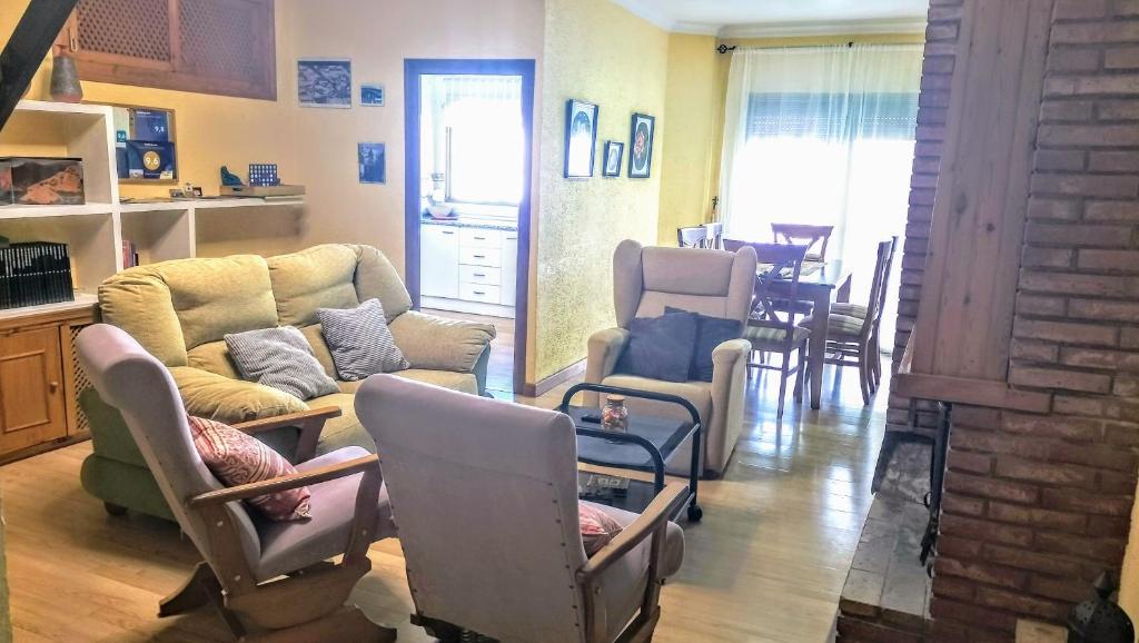 a living room with couches and chairs and a table at Casa Las Lomas in Prado del Rey