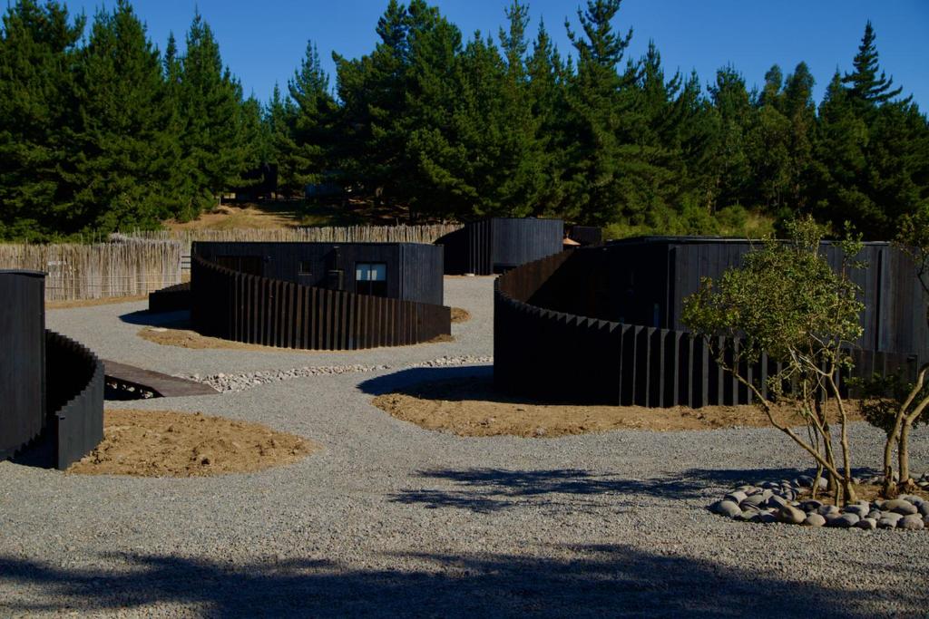 un jardin avec une clôture noire et des arbres dans l'établissement Bomar Lodge, à Puertecillo