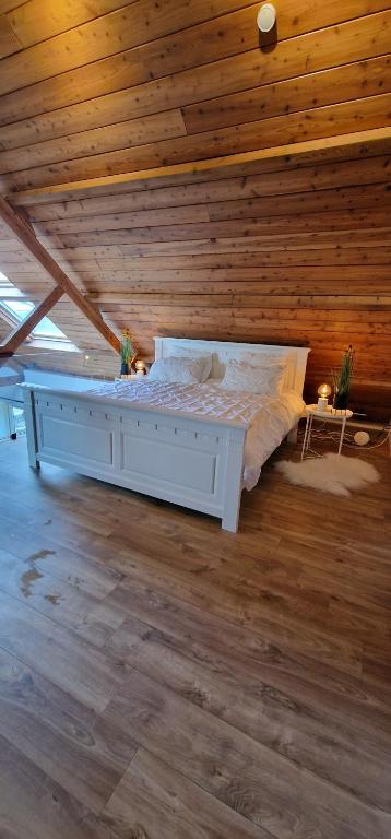 een groot bed in een kamer met een houten plafond bij Huize Dijkwater in Dreischor