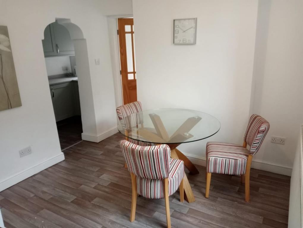 a glass table and two chairs in a room at Ty Twt in Wrexham