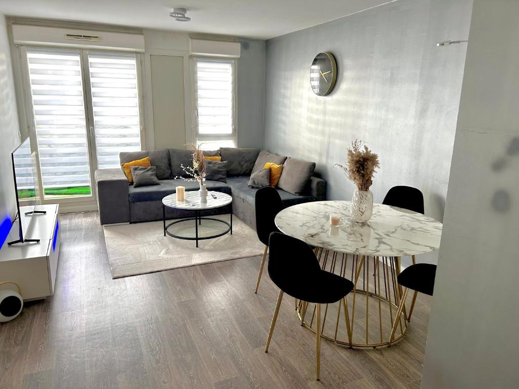 een woonkamer met een tafel en een bank bij Village olympique in Saint-Denis