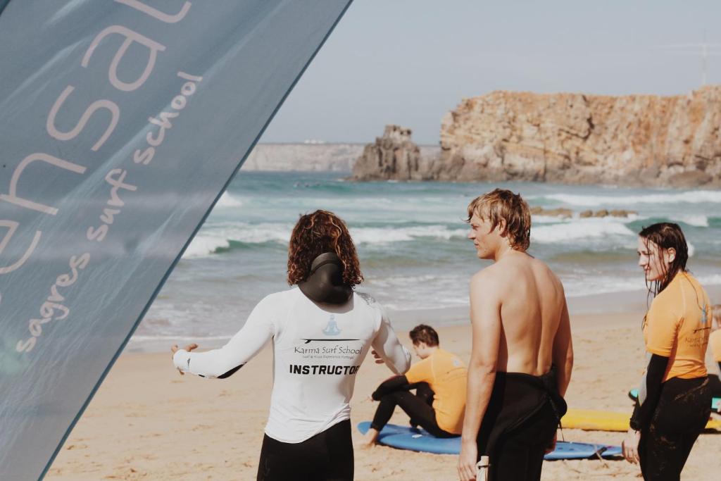 a group of people standing on the beach at Aldeia Caiçara Surf House in Sagres