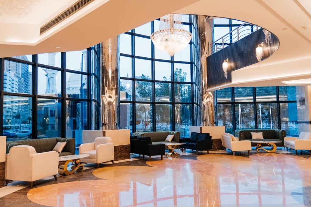 una hall con sedie, tavoli e finestre di فندق كابيتال جيست Capital Guest hotel a La Mecca