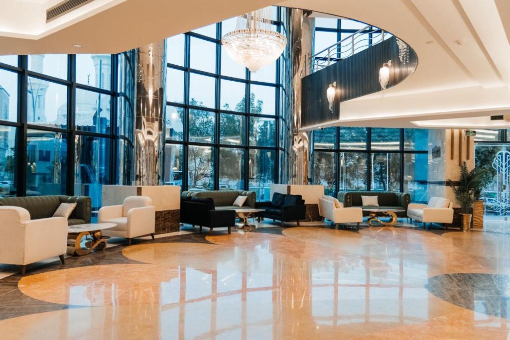 a lobby with chairs and tables and windows at فندق كابيتال جيست Capital Guest hotel in Mecca
