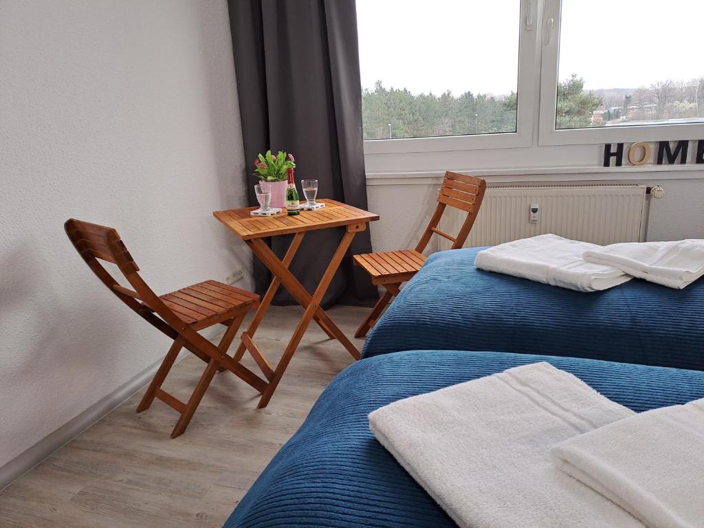 a room with two beds and a table with two chairs at NeueBurgK59, App, Kitchen and Bath in Muldenstein