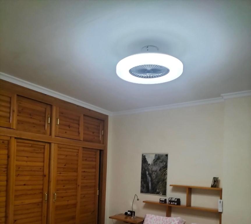 a ceiling light in a room with wooden cabinets at Casa Las Lomas in Prado del Rey