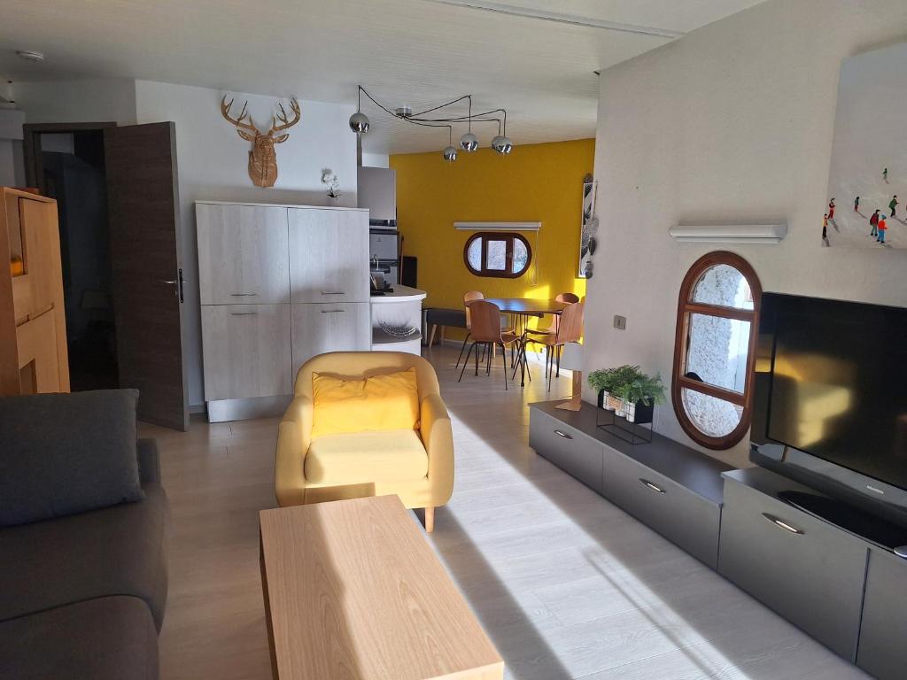 un salon avec un canapé et une télévision dans l'établissement Appartement les Orres 1650, aux Orres