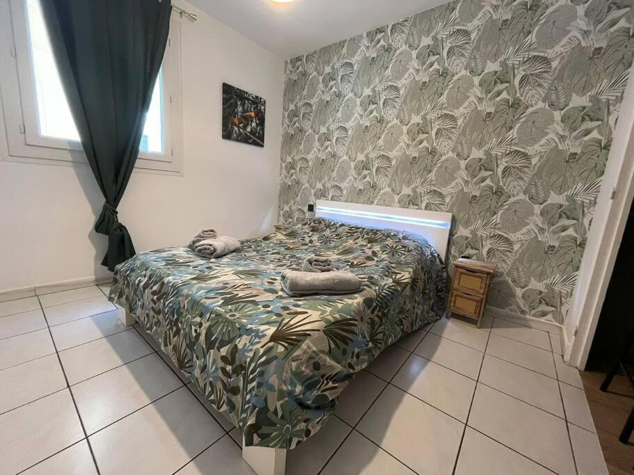 a bedroom with a bed with a green comforter at Spacieux appartement ~ Halles ~ Wifi ~ Centre in Narbonne