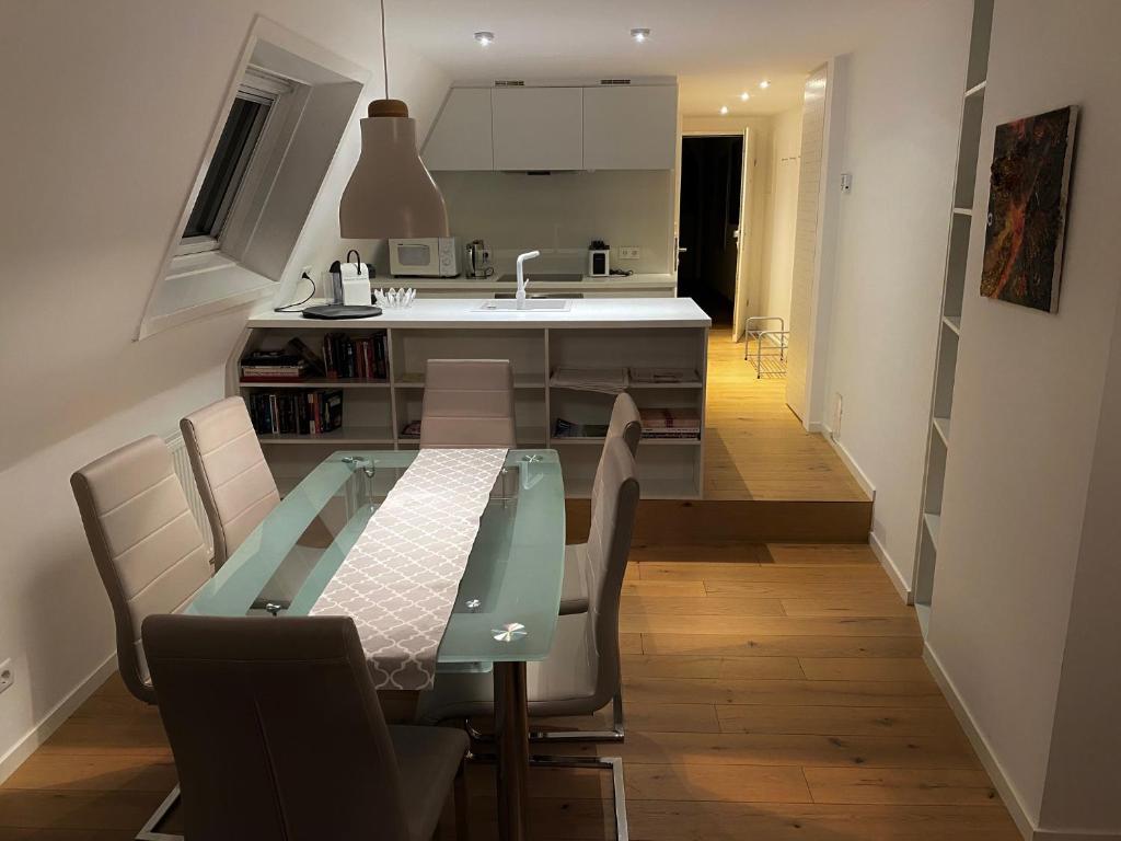 eine Küche mit einem Esstisch aus Glas und Stühlen in der Unterkunft Apartment in Grinzing in Wien