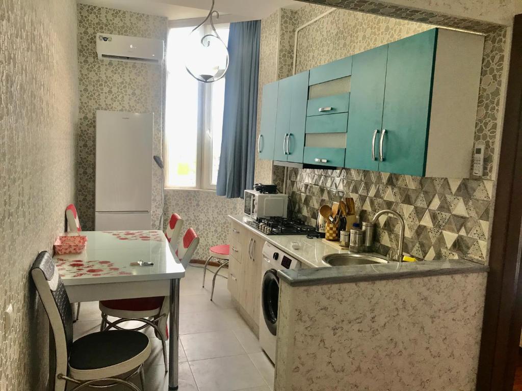 a kitchen with blue cabinets and a sink and a table at Best choice in Kutaisi