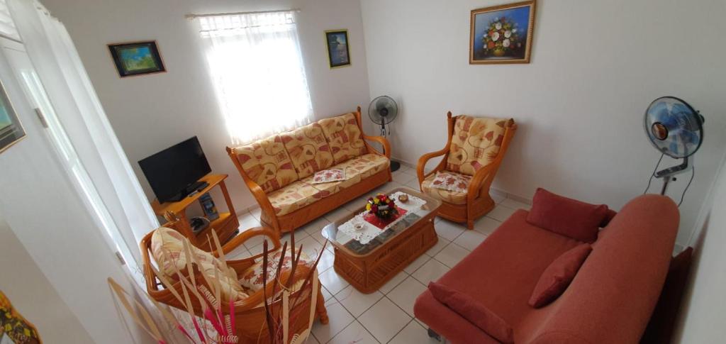 sala de estar con sofá y sillas en Le KREOL'GITES, en Capesterre-Belle-Eau