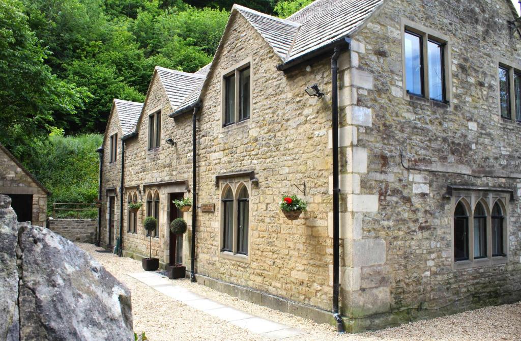 an old stone building with flowers on the windows at Springfield Coach House - Leisure and Business travellers in Stroud