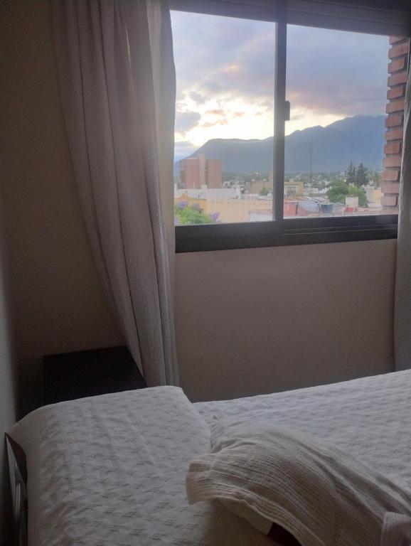 1 dormitorio con cama y ventana grande en Dpto Microcentro, vista panoramica en La Rioja
