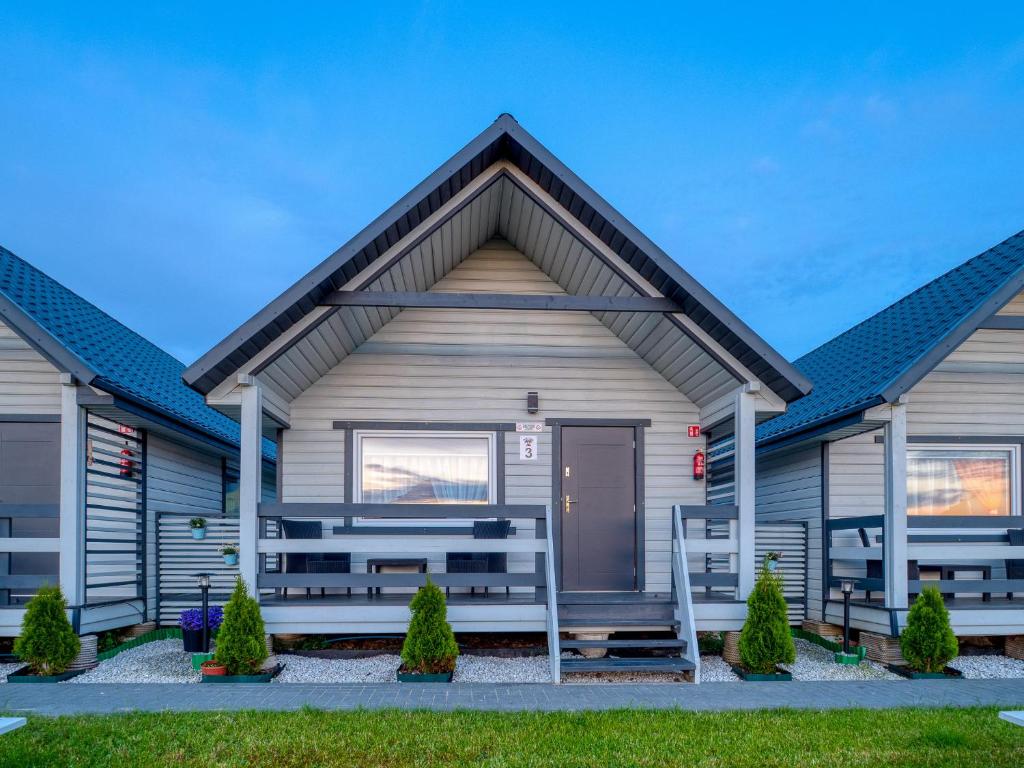 a house with a front door and benches at Domki Malibu in Rusinowo