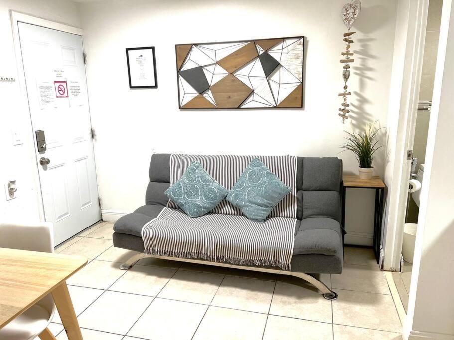 sala de estar con sofá y 2 almohadas en Cozy and sweet home, en Miami