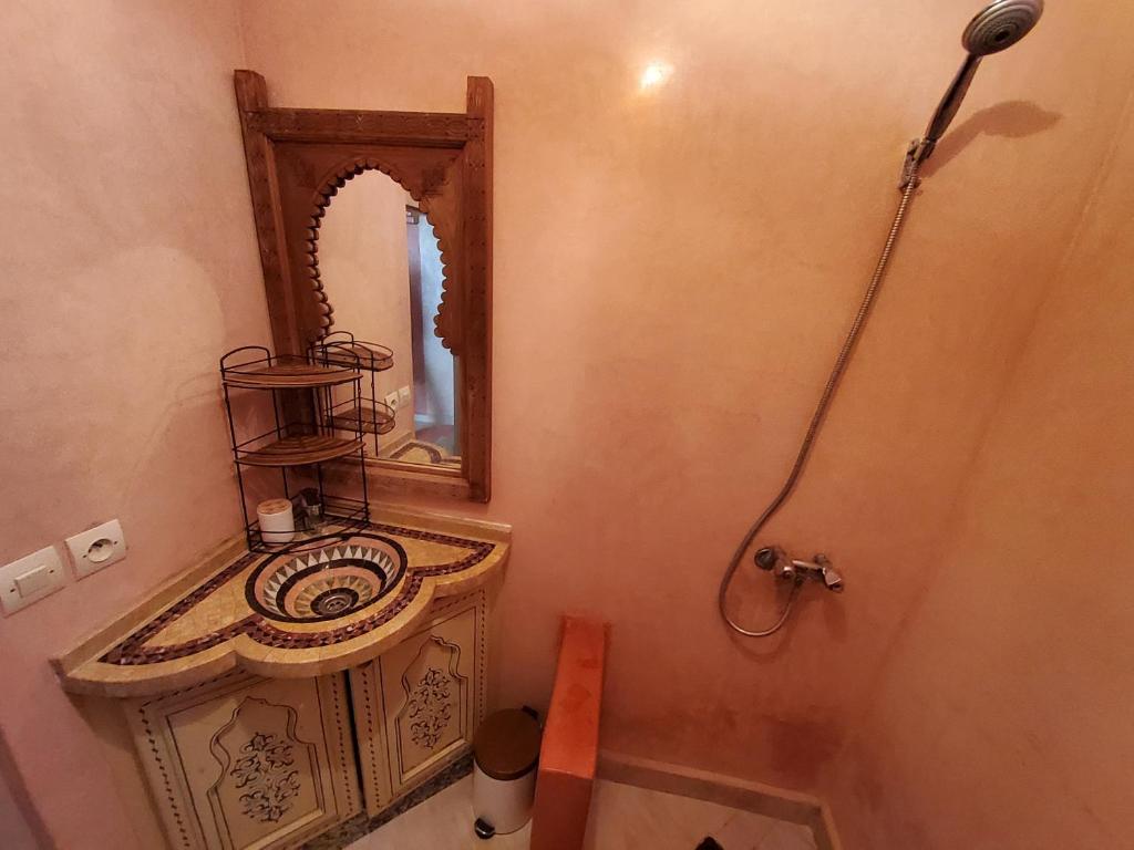 La salle de bains est pourvue d'un lavabo et d'un miroir. dans l'établissement Surf & Salsa GuestHouse, à Agadir