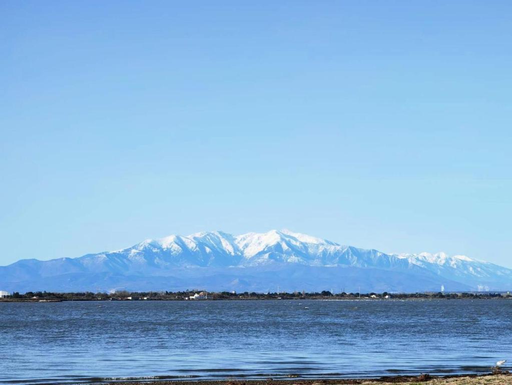 une grande étendue d'eau avec des montagnes en arrière-plan dans l'établissement Résidence Grenada - T2 4 couchages LE BARCARES - climatisé, avec accès internet MAE-0611, au Barcarès