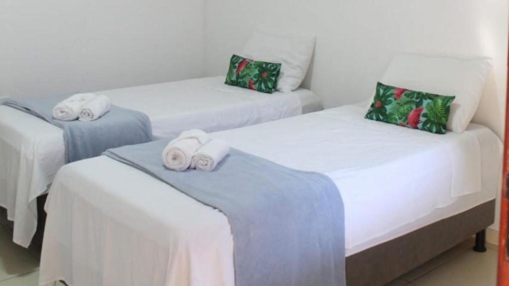two beds in a room with towels on them at Pousada Vila Jesuita in Cairu