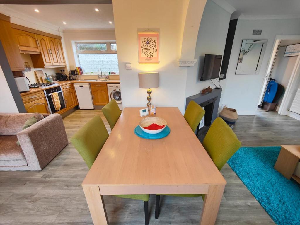 een keuken en een woonkamer met een houten tafel en stoelen bij Peaceful 3 Bedroom House wFree Parking Nature in Falmer