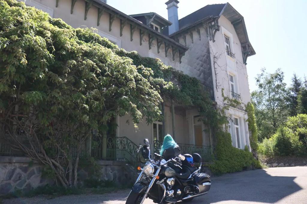 a motorcycle parked in front of a house at L'ancien Mystic ManOir DeDame in Ventron