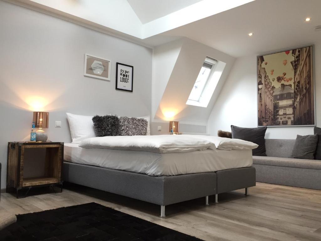 a bedroom with a bed and a couch at Boutique-Hotel "Stilvoll" in Andernach