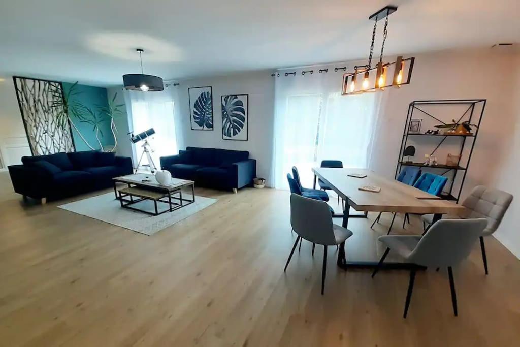 ein Wohnzimmer mit einem Tisch und einem blauen Sofa in der Unterkunft La Sauldre, maison au cœur de la Sologne in Lamotte-Beuvron