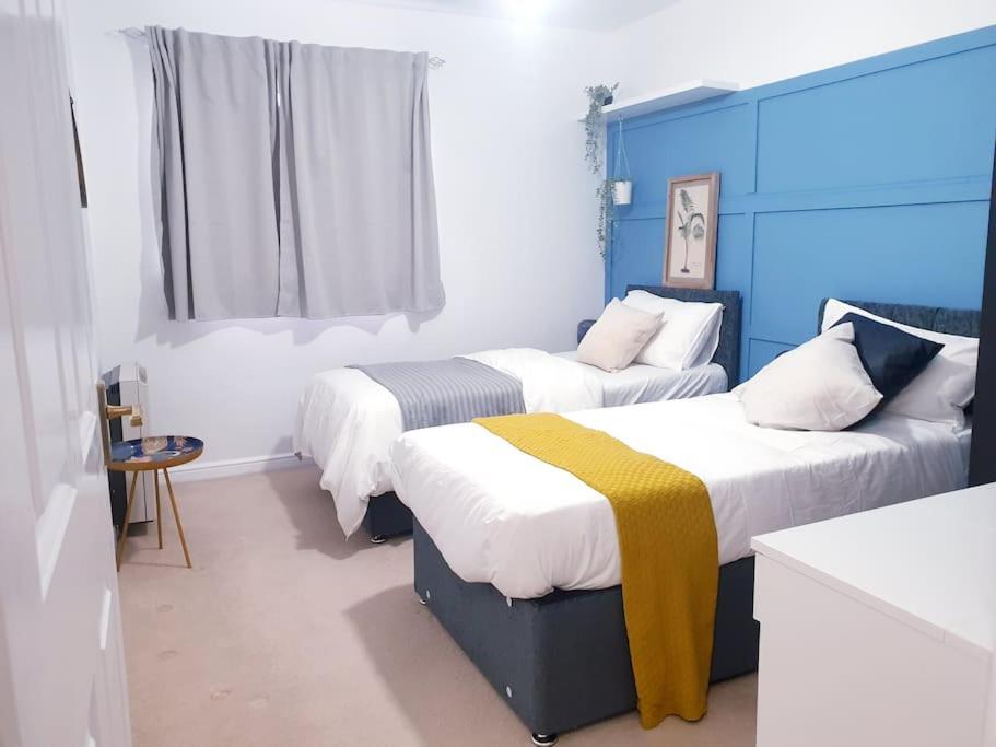 2 camas en una habitación de color azul y blanco en Hyde Park - Park Hill - Central - 2 Bedrooms - Free On-Site Parking - Netflix - Fast WiFi en Sheffield