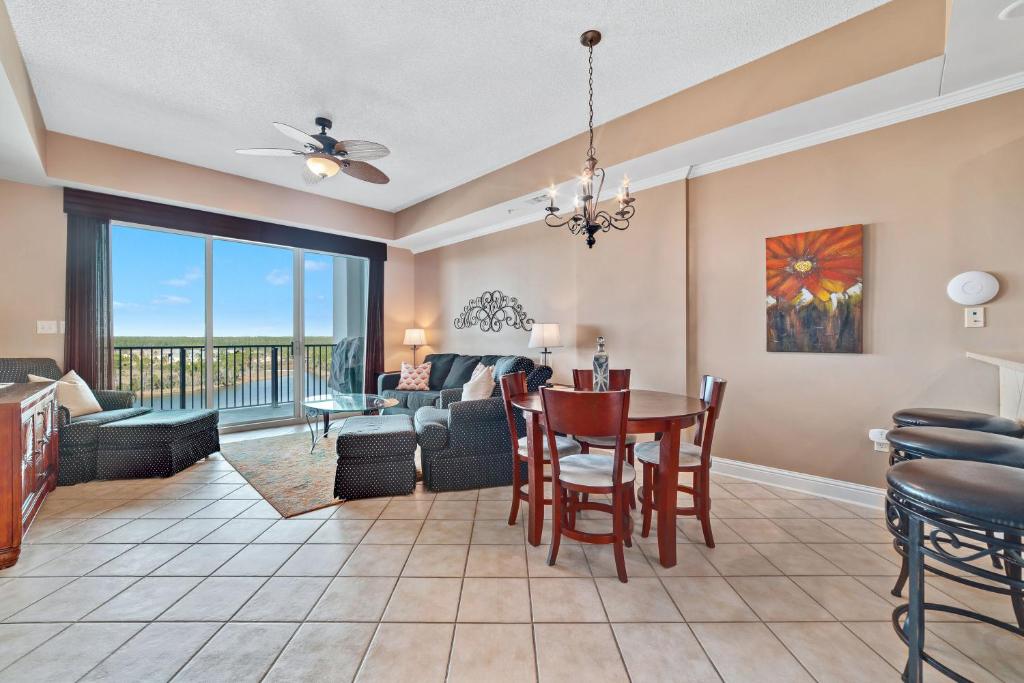 una sala da pranzo e un soggiorno con tavolo e sedie di The Wharf Unit 717 a Orange Beach