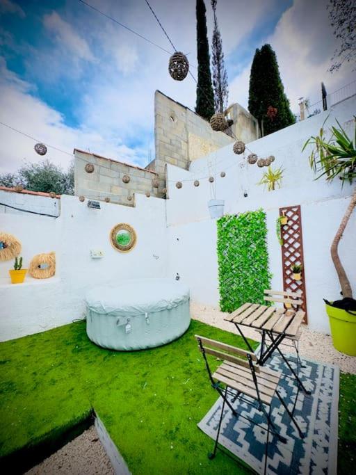 une cour avec deux bancs et un mur avec des plantes dans l'établissement Petite maison avec terrasse, à La Penne-sur-Huveaune