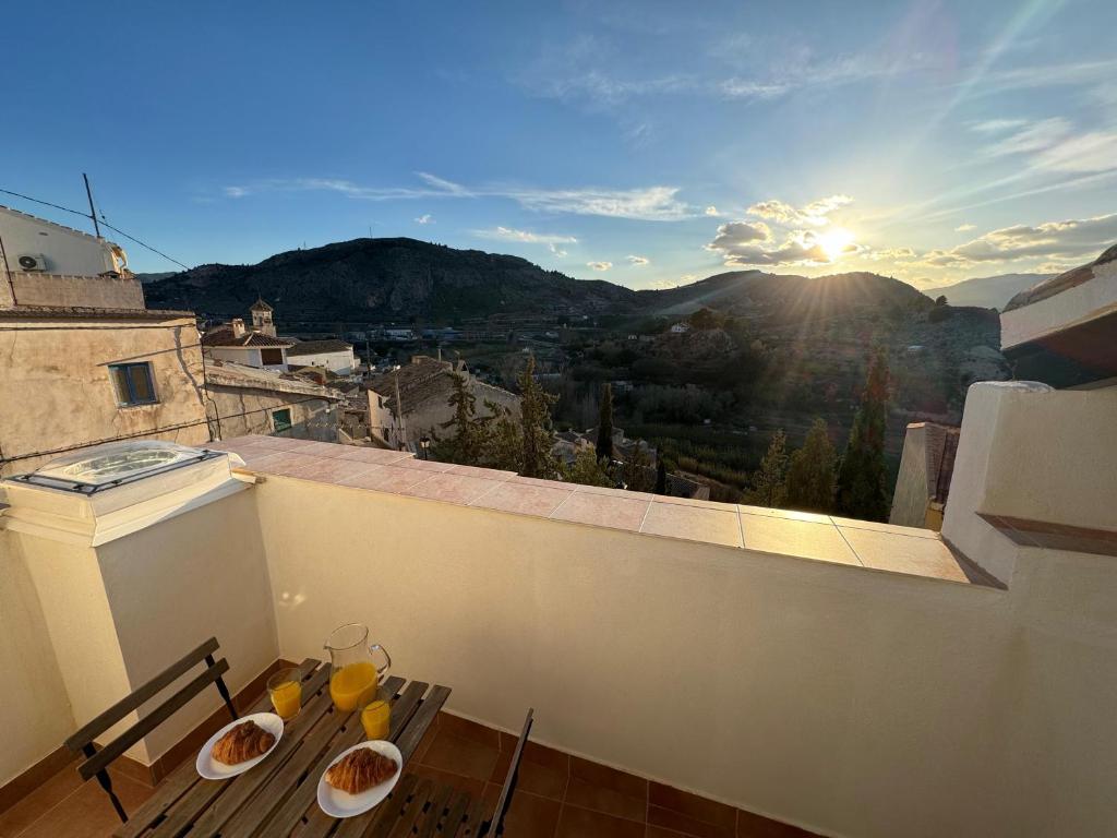un balcón con una mesa con tazones de naranjas. en Casa Rural El Alcázar - Cehegín en Cehegín
