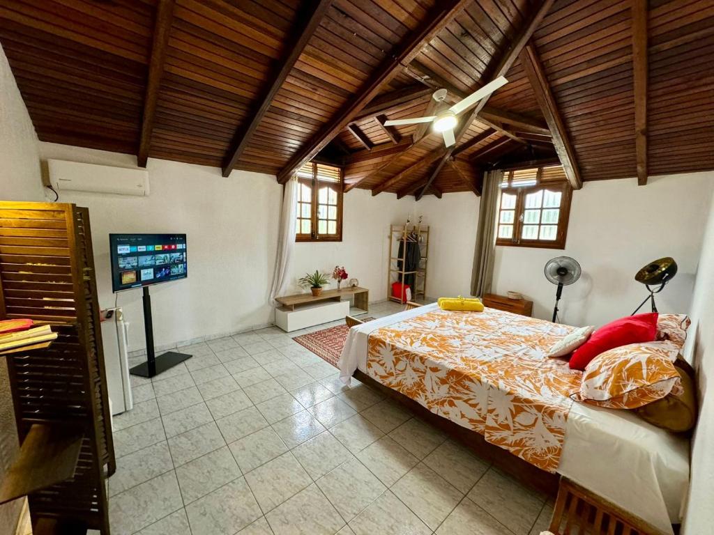 una camera da letto con un letto e una TV a schermo piatto di Sunset Sea View a Vieux-Habitants