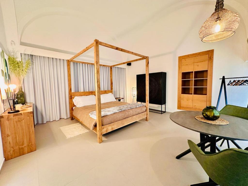 um quarto com uma cama de dossel e uma mesa em Suite 1926 Luxury Room em Triggiano