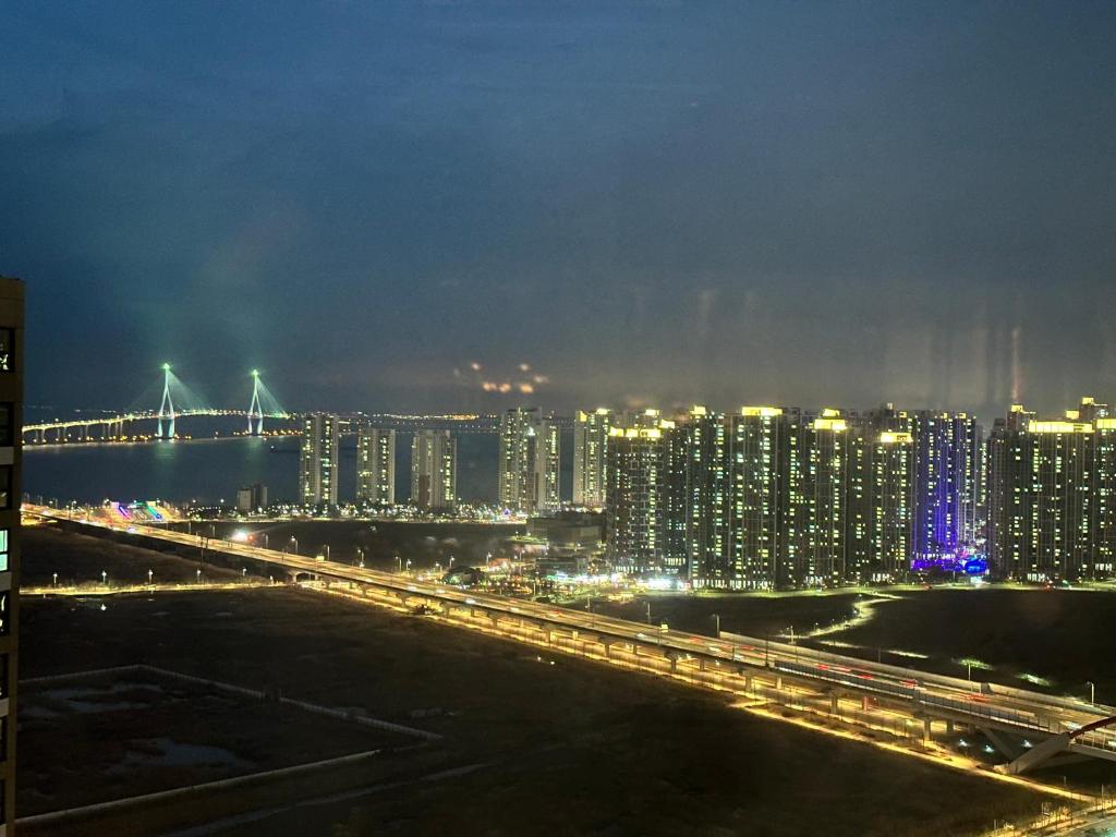 a city at night with a bridge and buildings at Trip to Songdo in Incheon