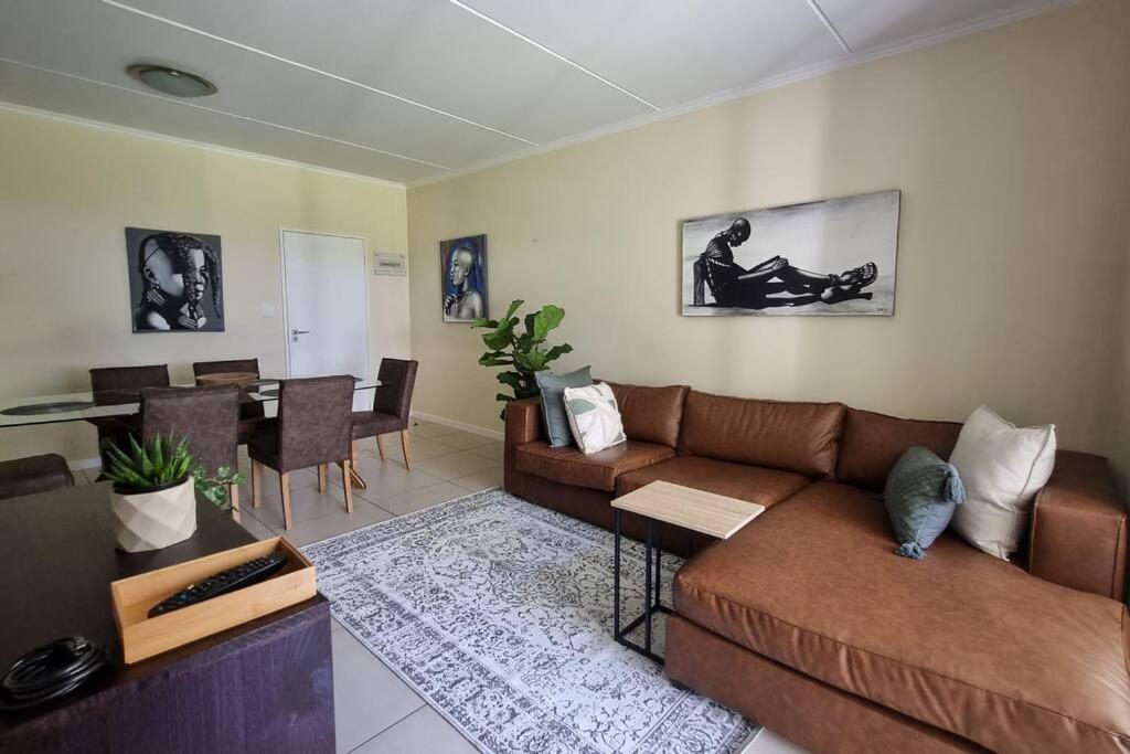 a living room with a couch and a dining room at Home Away From Home in Midrand