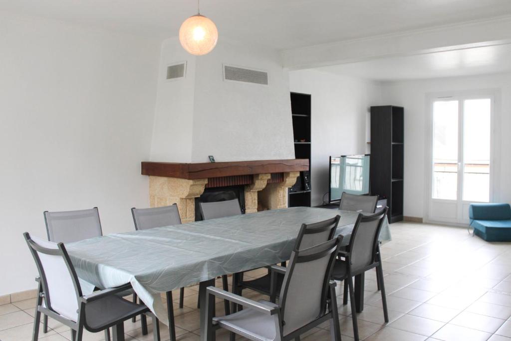 uma sala de jantar com uma mesa e cadeiras e uma lareira em Cozy and spacious house in Saint-Denis em Saint-Denis