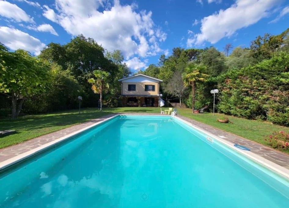 ein Haus mit einem Pool vor einem Haus in der Unterkunft Heerlijke villa met privé zwembad & 5 slaapkamers dicht bij Lucca en Pisa in Monsagrati