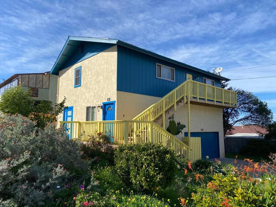 a large house with blue doors and a balcony at Pelican Place in Morro Bay in Morro Bay